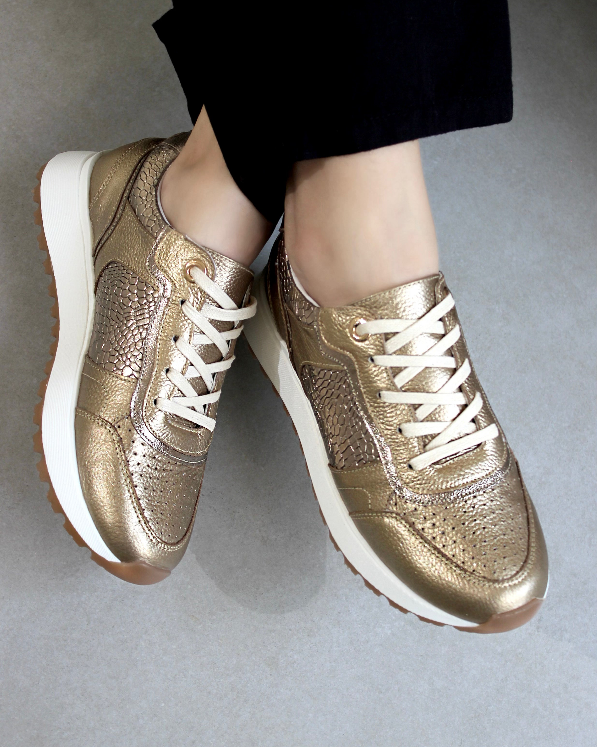 Sneakers en cuero premium, plantilla confort y suela liviana. Tenis color dorado. Diseño versátil y de alta calidad.